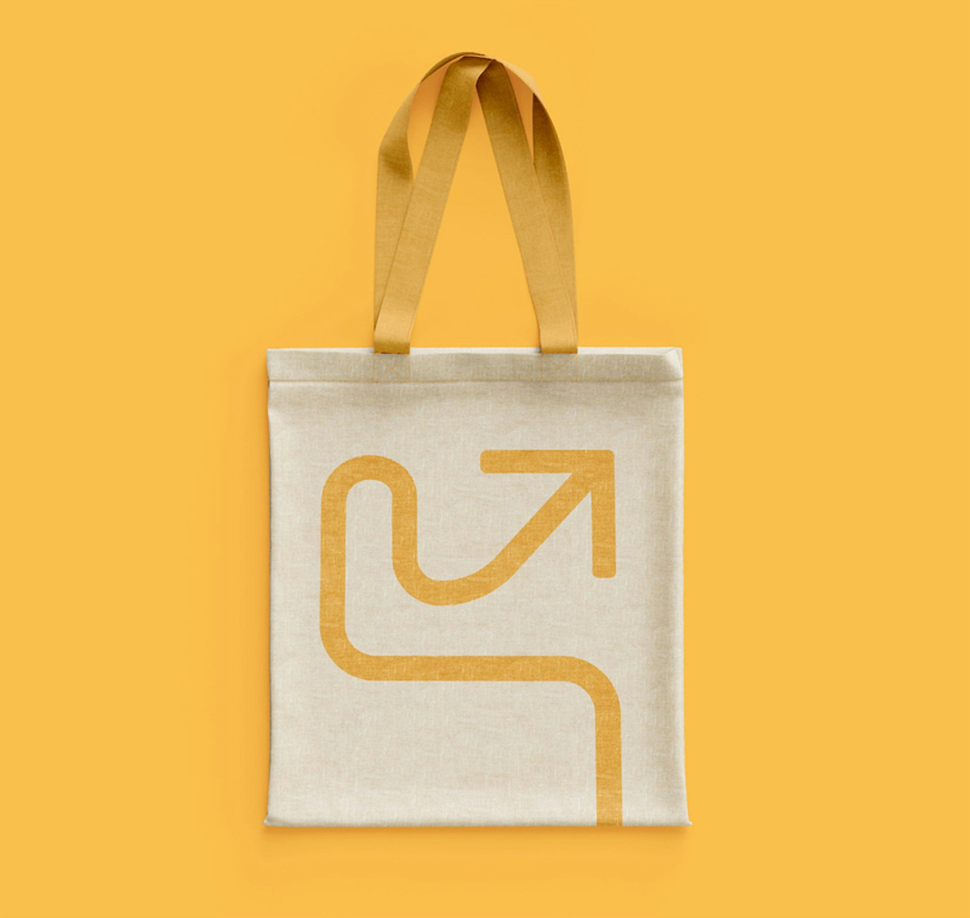Tote bag with yellow arrow key visual on yellow background.