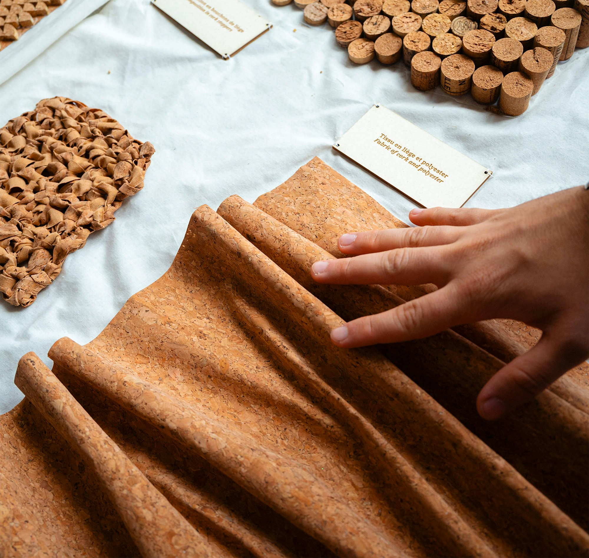 Photography of cork material being touched by a visitors hand.