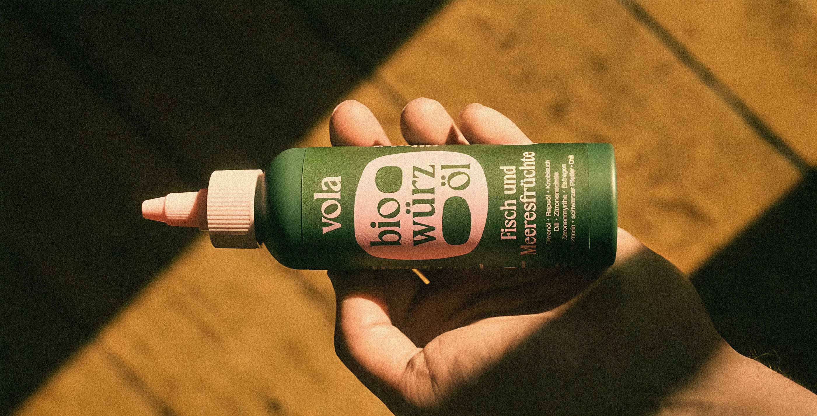 New packaging for vola hold by a hand in front of a wooden floor.